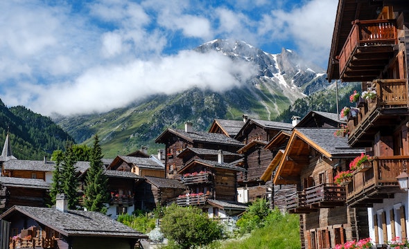 Wooden Swiss chalet surrounded by scenic mountains